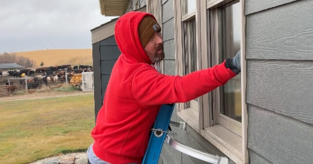 man on ladder cleaning residential windows